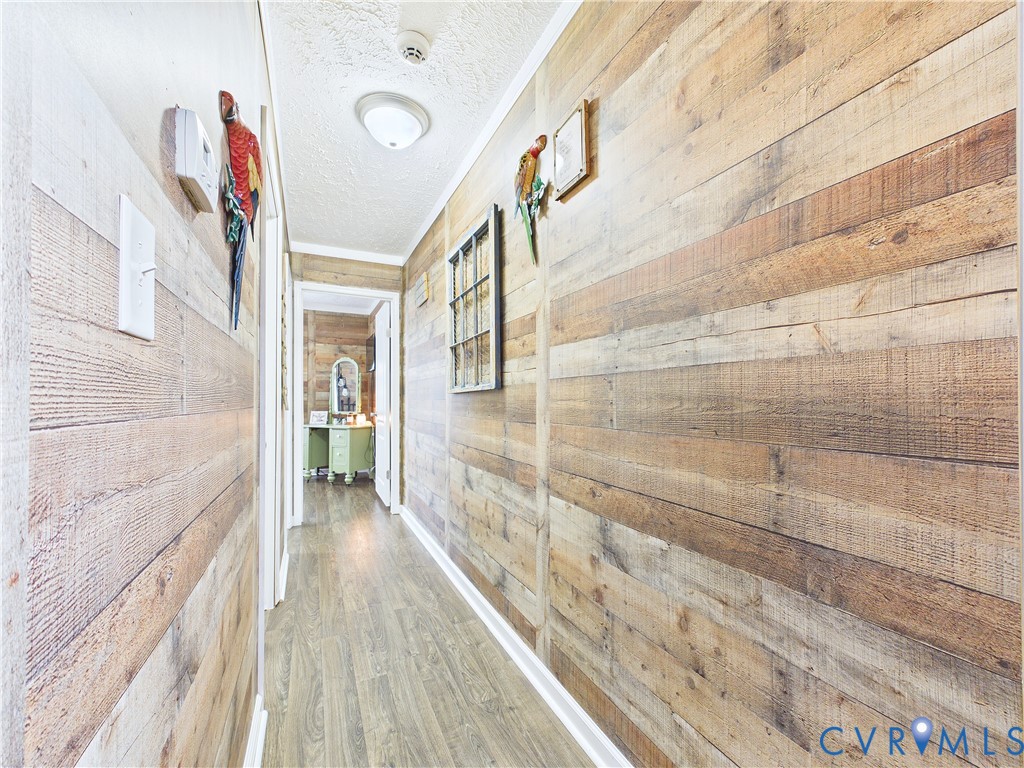 Hallway featuring horizontal wood-plank wall treatments and wood-finish flooring