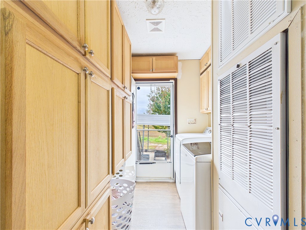 Full-length wood-finish cabinetry, metal louvered wall panels, and glass-paned exterior door with hardware