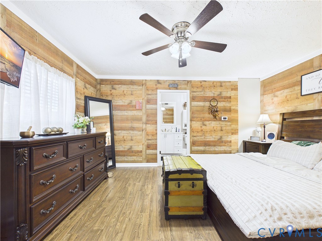 Horizontal wood plank wall paneling, wood-finish flooring, and a multi-light ceiling fan Horizontal wood plank wall paneling, wood-finish flooring, and a multi-light ceiling fan