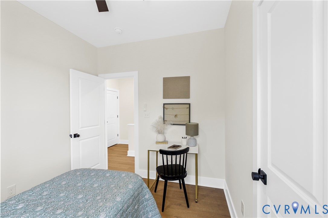 Neutral wall paint, wood-finish flooring, and two-panel interior doors with matte black hardware