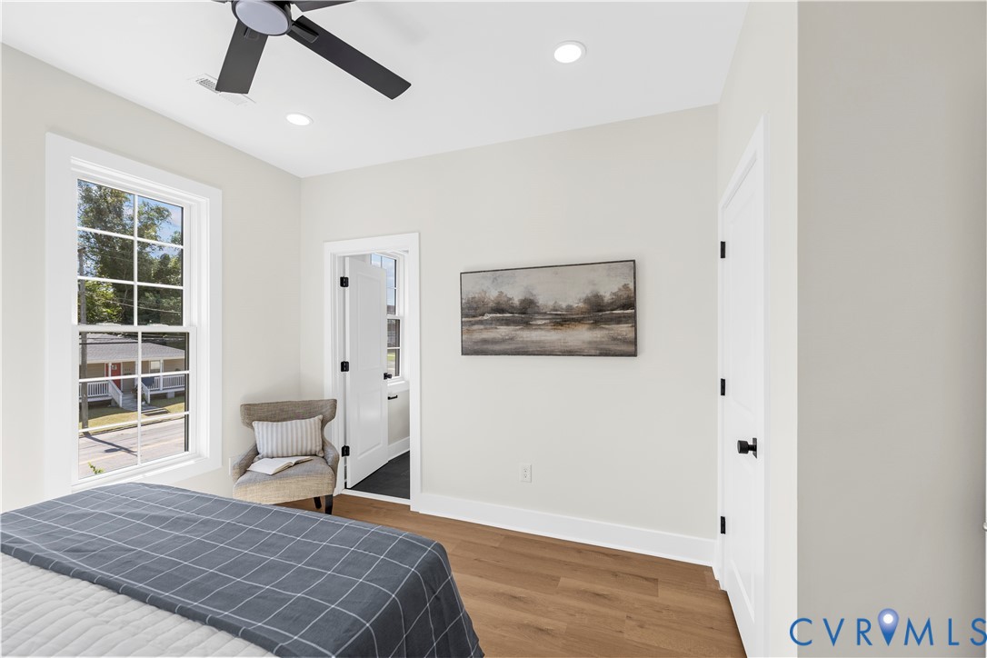 Room featuring wood-finish flooring, recessed lighting, a matte black ceiling fan, and a multi-pane window with white trim