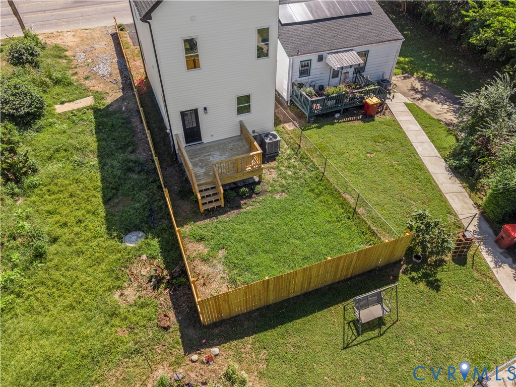 Rear exterior featuring a wood deck with stairs, a fenced-in yard, and vinyl siding
