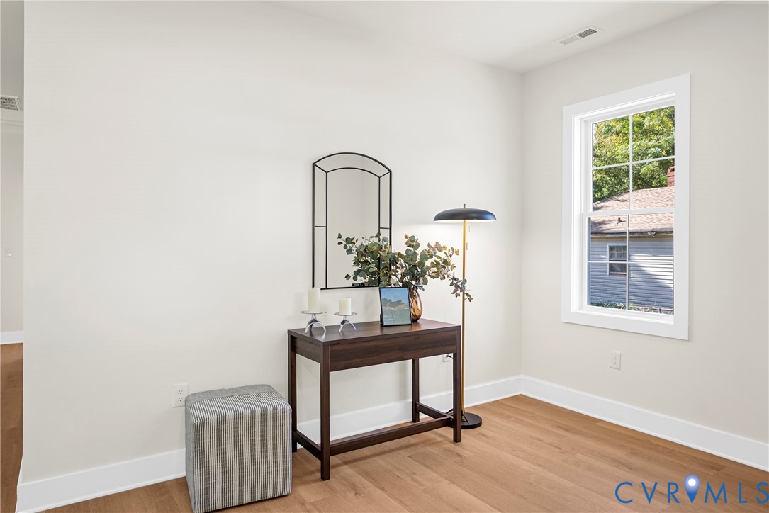 Neutral wall tones, wood-finish flooring, and a single-hung window with muntin grid detailing