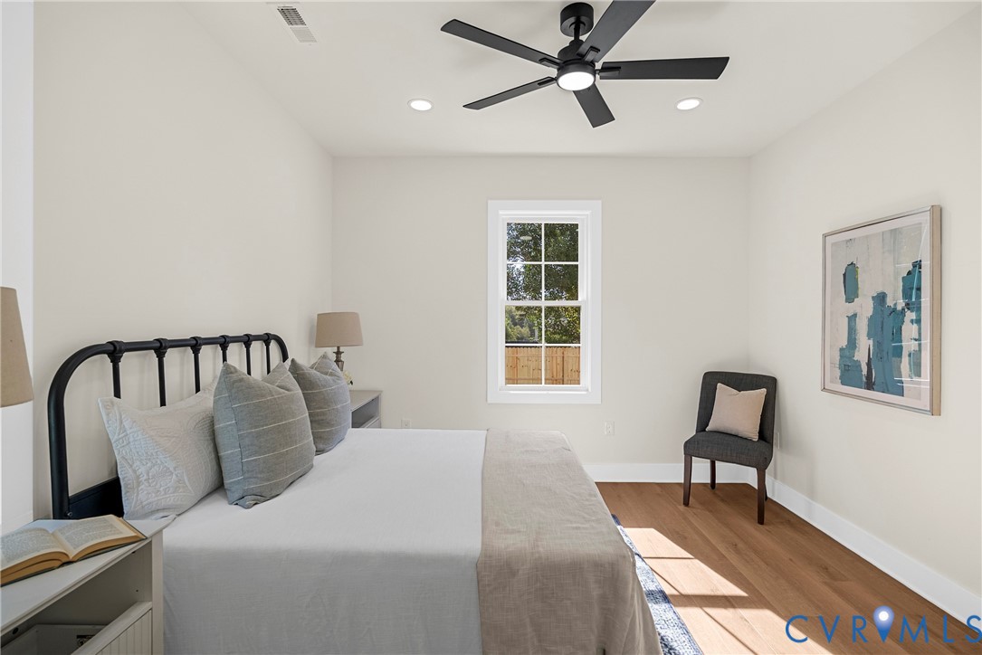 Room featuring wood-finish flooring, a central ceiling fan with integrated lighting, recessed lighting, and a single-hung window with muntin detailing