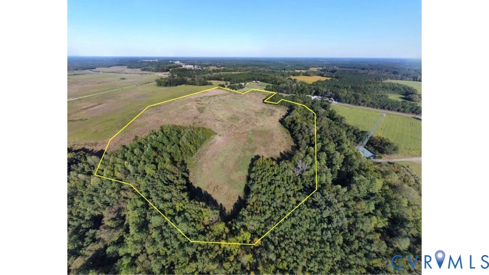 Expansive acreage featuring cleared open terrain, dense perimeter woodlands, and defined boundary lines