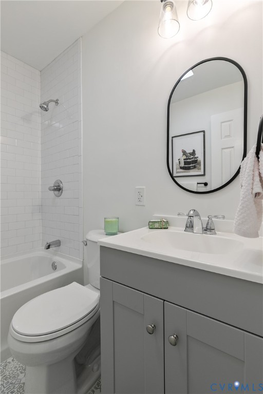 Bathroom featuring a grey vanity with a white countertop, oval mirror with a matte black frame, white subway tile shower surround, and chrome hardware