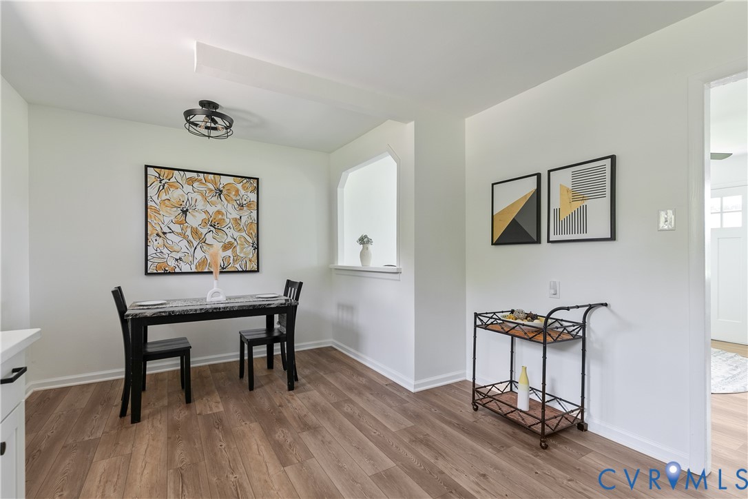 Wood-finish flooring, architectural wall cutout, and industrial-style flush mount ceiling lighting