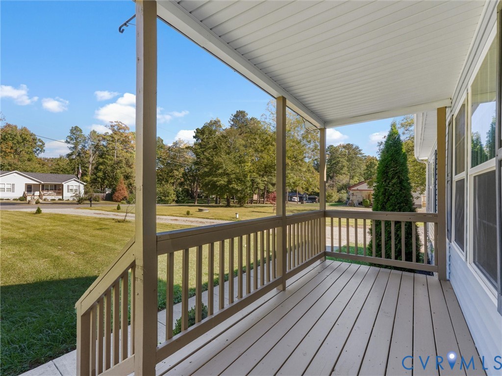 Covered front porch featuring wood-plank flooring, painted railing, and overhead beadboard paneling Covered front porch featuring wood-plank flooring, painted railing, and overhead beadboard paneling