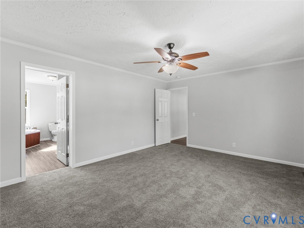 Neutral-toned wall paint, wall-to-wall carpeting, and a central ceiling fan with integrated lighting