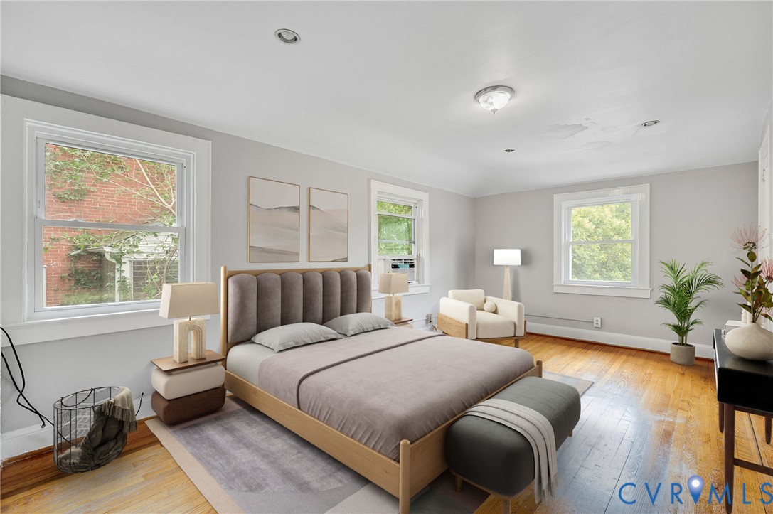 Spacious room featuring wood-finish flooring, recessed lighting, and multiple windows with white trim