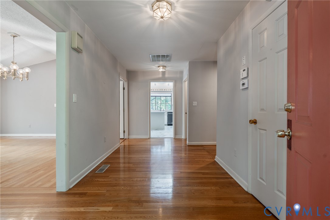 Foyer featuring wood-finish flooring, neutral wall paint, and multi-light flush-mount fixtures