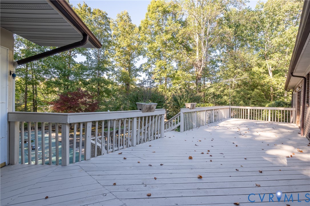 Expansive multi-level wood deck featuring white railing and integrated stairs