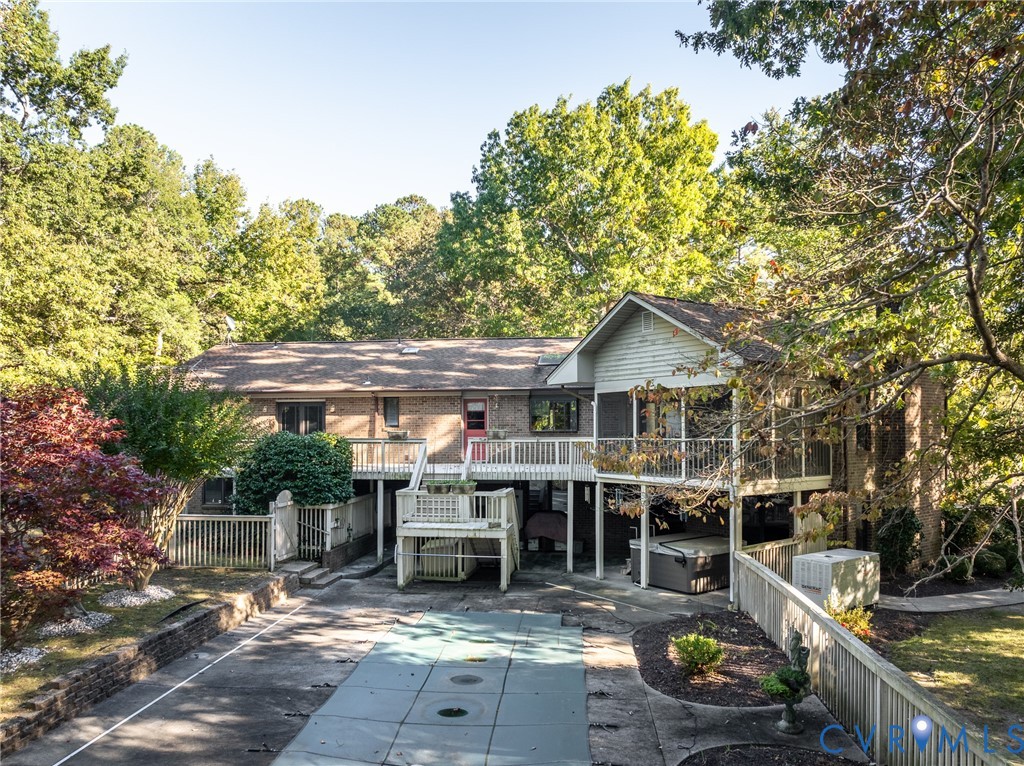 Brick and siding exterior featuring a multi-level deck, screened-in porch, in-ground pool, and privacy fencing