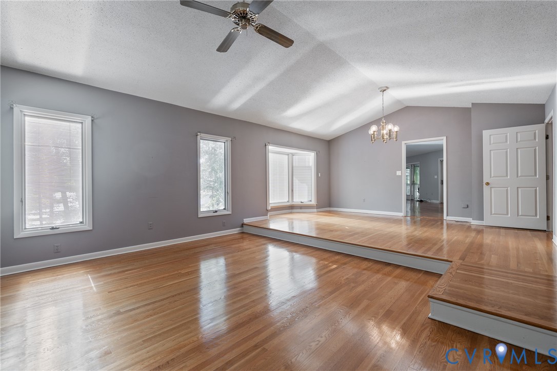 Vaulted ceilings, wood-finish flooring, recessed bay window, multi-level design, and tiered platform