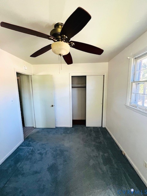 Ceiling fan with integrated lighting, wall-to-wall carpeting, and a closet with sliding doors