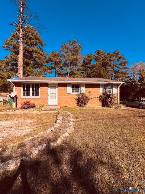 Single-story brick exterior featuring a multi-pane window configuration, decorative window shutters, and a stone-lined garden border Single-story brick exterior featuring a multi-pane window configuration, decorative window shutters, and a stone-lined garden border