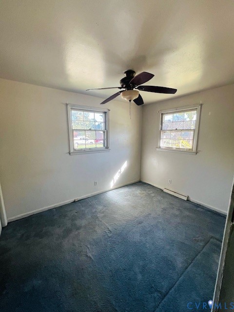 Room featuring neutral-toned walls, carpeting, two multi-pane windows, and a ceiling fan with integrated lighting