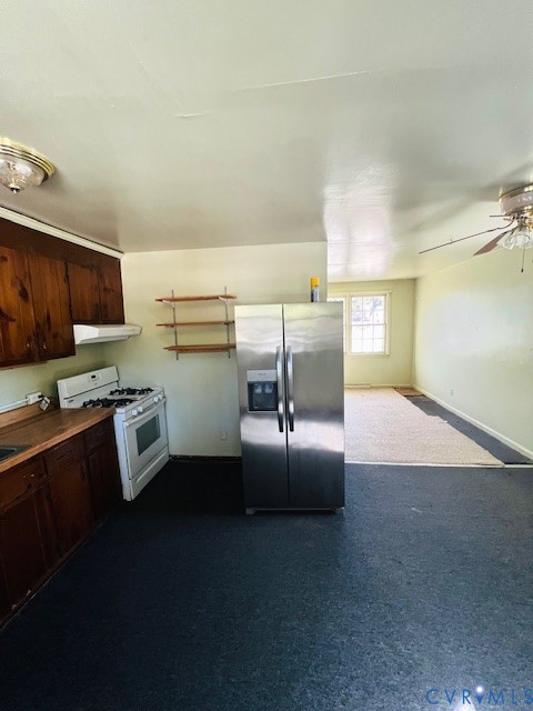 Kitchen featuring wood cabinetry, stainless steel side-by-side refrigerator, white gas range with overhead exhaust hood, and wall-mounted shelving