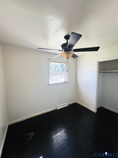 Interior space featuring wood-finish flooring, a ceiling fan with integrated lighting, a window, and a reach-in closet with an installed rod