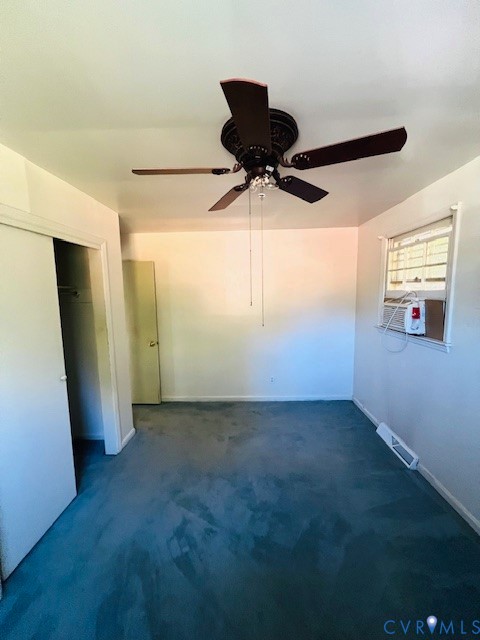 Room featuring carpeting, a ceiling fan with integrated light fixture, a closet with sliding doors, and a window