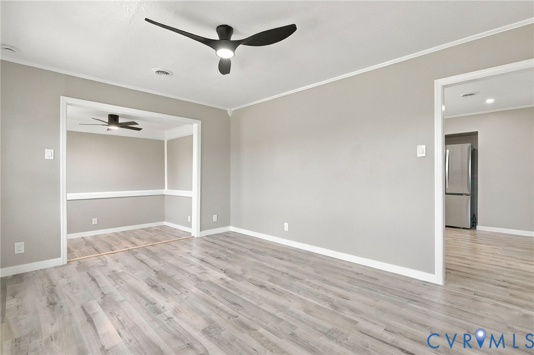 Wood-finish flooring, neutral wall tones, multi-blade ceiling fans, and chair rail molding Wood-finish flooring, neutral wall tones, multi-blade ceiling fans, and chair rail molding