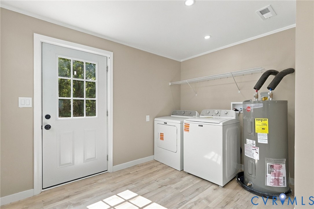 Utility room featuring wood-finish flooring, a multi-pane glass door, and built-in wire shelving