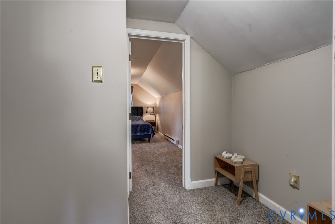 Sloped ceilings with neutral-toned paint and plush carpeting