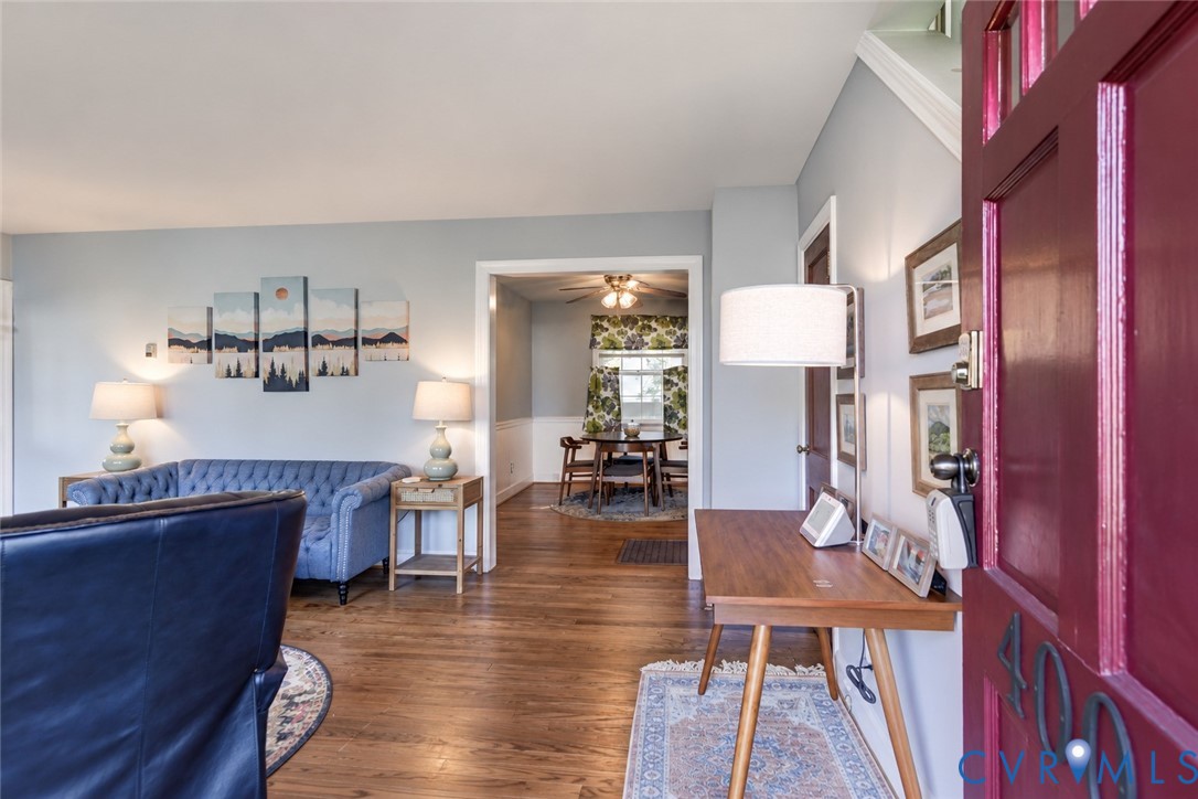 Entryway featuring a solid wood door with glass pane inserts, hardwood flooring, and chair rail molding