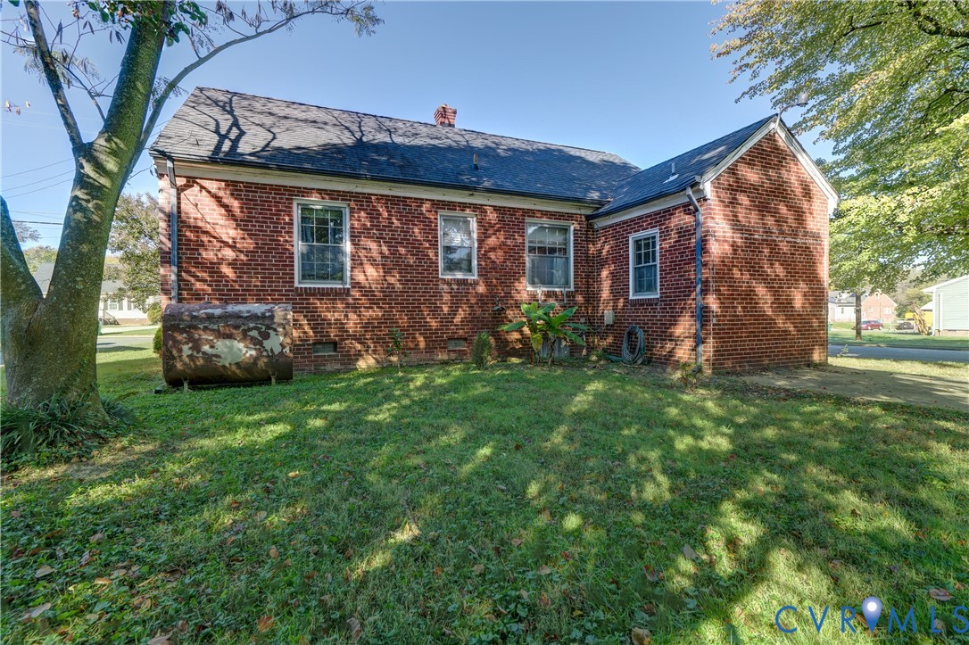 Red brick exterior featuring a multi-gable roofline, asphalt shingles, and multi-pane windows