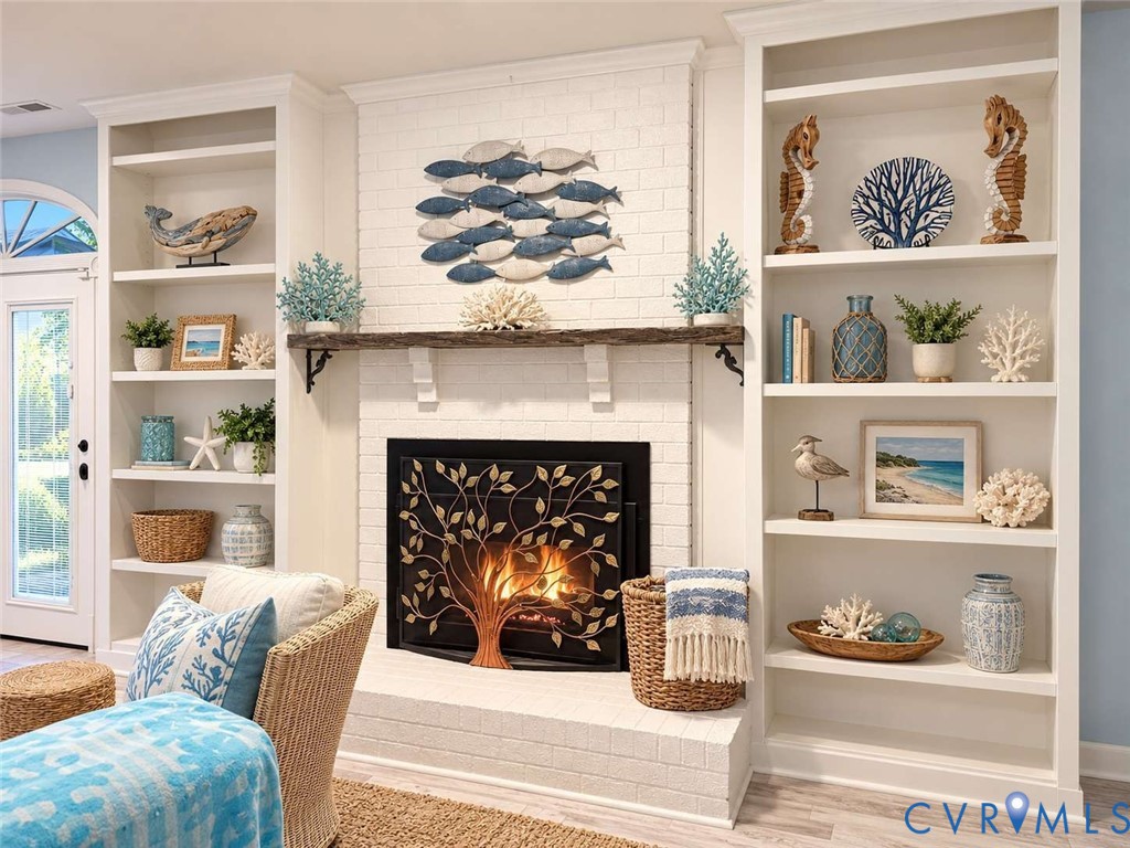 Fireplace featuring a white painted brick surround, a rustic wood mantel, and built-in floor-to-ceiling shelving