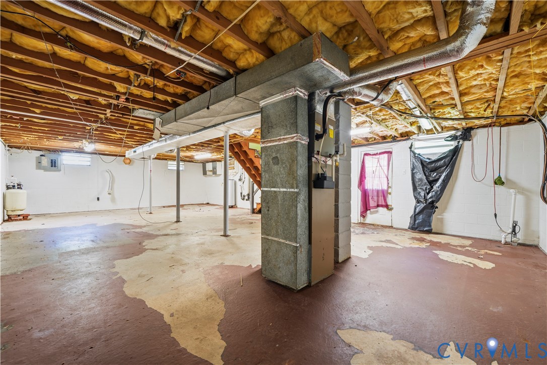Unfinished basement area featuring exposed joists, painted concrete flooring, metal support columns, and an HVAC system