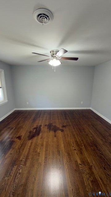 Room featuring dark-stained hardwood flooring, neutral wall tones, and a ceiling-mounted fan with integrated light fixture