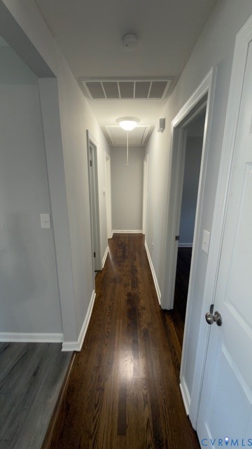 Hallway featuring wood-finish flooring, neutral interior paint, and flush-mount ceiling lighting