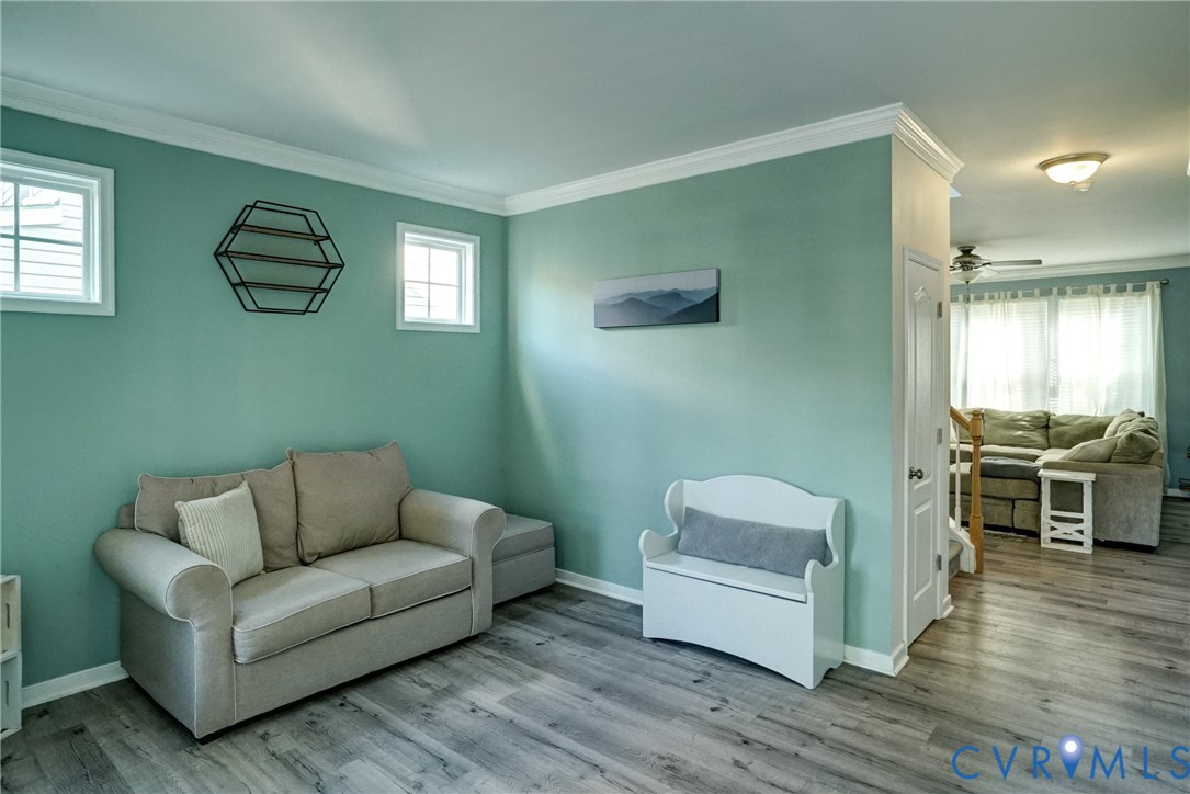 Interior space featuring wood-finish flooring, crown molding, and double-hung windows