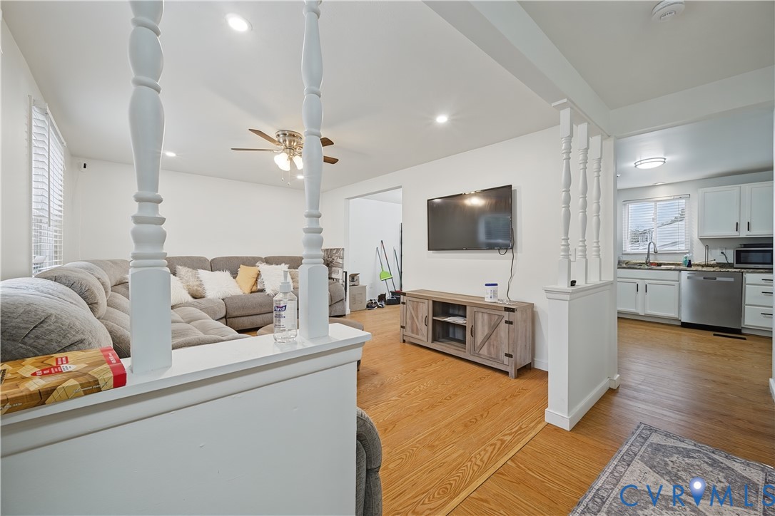 Living area featuring wood-finish flooring, decorative spindle partition walls, and recessed lighting Living area featuring wood-finish flooring, decorative spindle partition walls, and recessed lighting