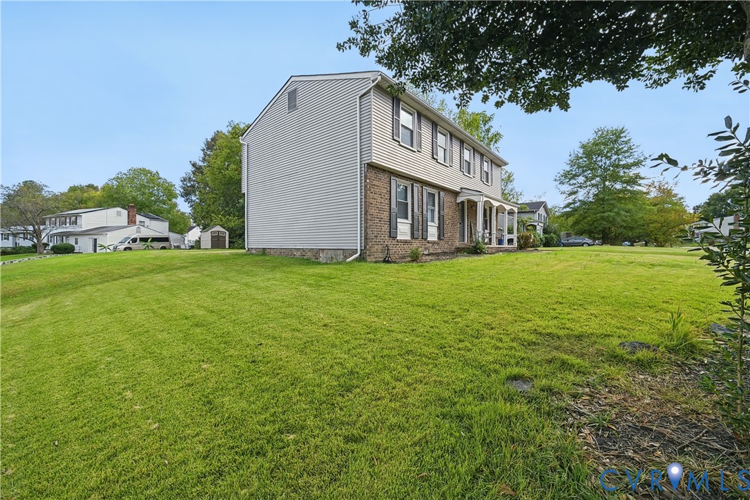 Two-story exterior featuring light-toned horizontal siding, a partial brick facade, shuttered windows, and an expansive lawn Two-story exterior featuring light-toned horizontal siding, a partial brick facade, shuttered windows, and an expansive lawn