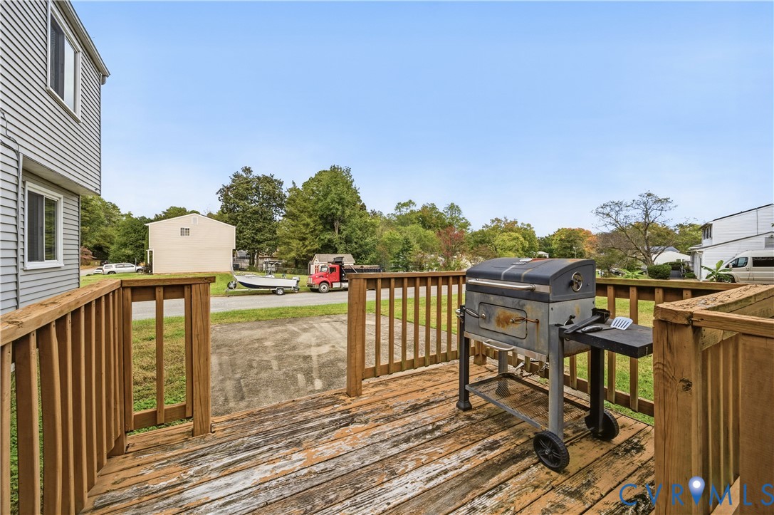 Elevated wood-plank deck featuring a perimeter railing and concrete ground-level surface