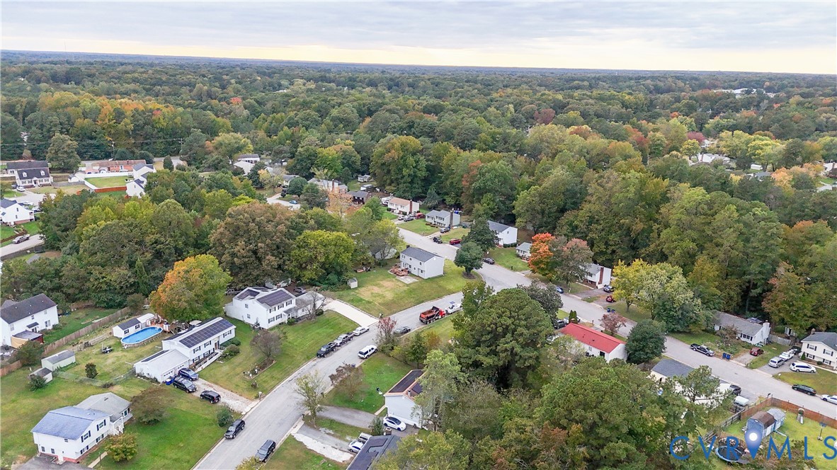 Aerial perspective featuring established residential streets, mature tree canopy, and varied suburban topography