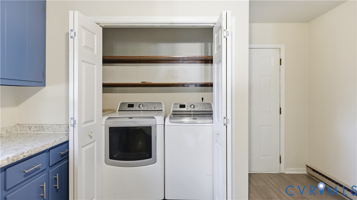 Laundry area featuring bi-fold doors, built-in shelving, blue cabinetry, and speckled-pattern countertop