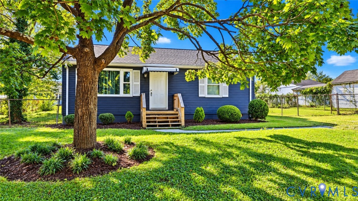 Single-story residence featuring navy blue siding, white window shutters, an asphalt shingle roof, and a wood-frame entryway staircase
