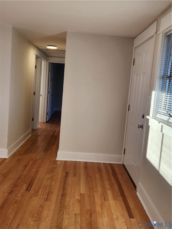 Wood-finish flooring, multi-panel interior doors, and a window with fitted blinds
