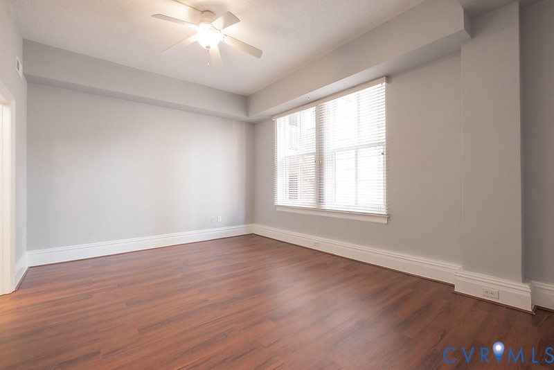 Interior room featuring wood-finish flooring, recessed ceiling lighting with an integrated fan, neutral wall paint, and windows fitted with horizontal blinds