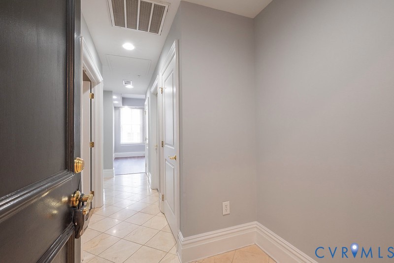 Interior entry featuring light-toned tile flooring, neutral wall paint, recessed lighting, and multi-panel doors with metallic hardware