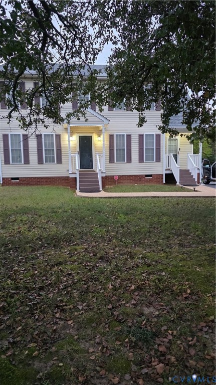Two-story exterior featuring light-toned horizontal siding, brick foundation masonry, and decorative window shutters, accented by dual entryways with covered stoops Two-story exterior featuring light-toned horizontal siding, brick foundation masonry, and decorative window shutters, accented by dual entryways with covered stoops