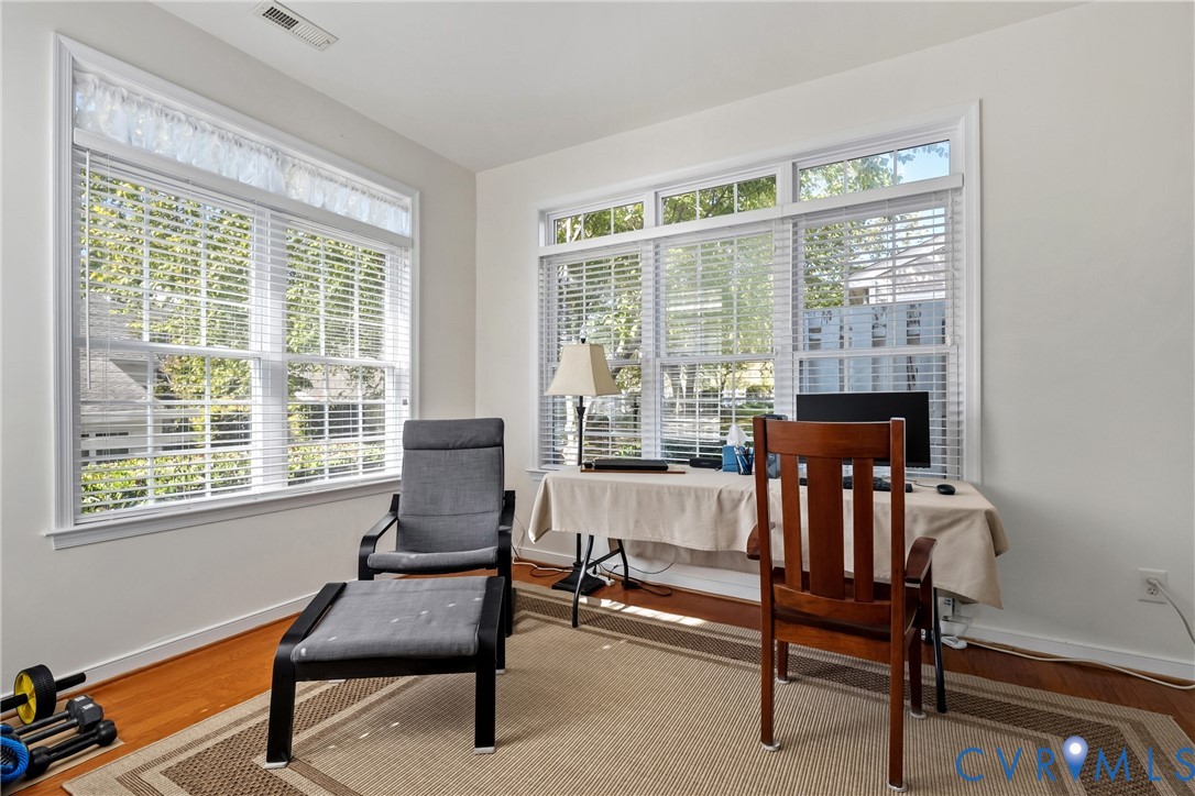Bright interior space featuring multi-pane window configurations, white trim, and wood-finish flooring