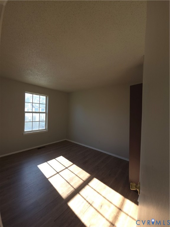 Interior space featuring wood-finish flooring, a single-hung window with a multi-pane grid, and neutral wall tones Interior space featuring wood-finish flooring, a single-hung window with a multi-pane grid, and neutral wall tones