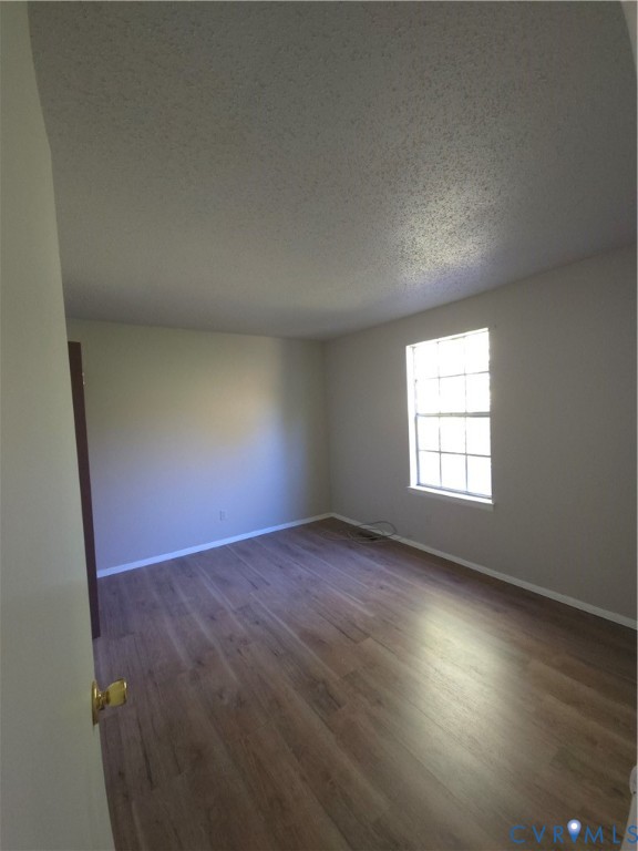 Interior space featuring neutral wall paint, wood-finish flooring, and a single-hung window with a grid pattern