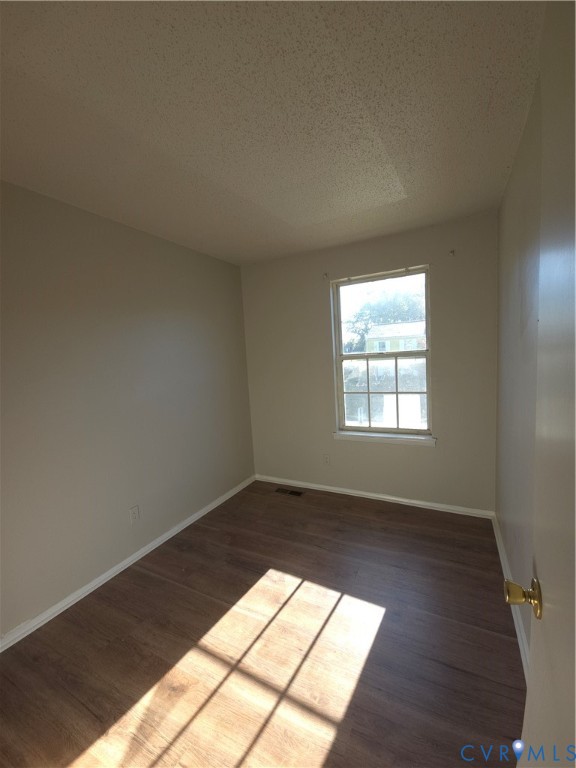 Room featuring neutral-toned walls, wood-finish flooring, and a single-hung window with a multi-pane grid