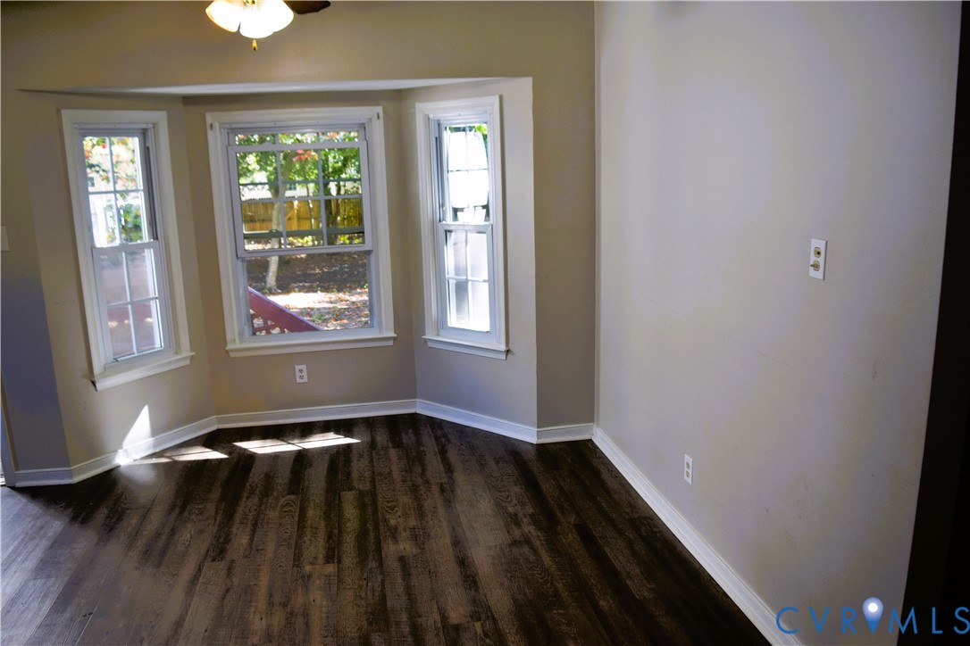 Bay window with multi-pane windows, wood-finish flooring, and a ceiling-mounted light fixture