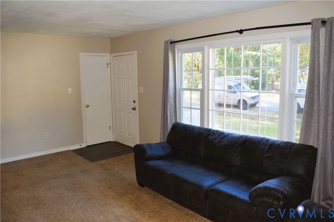 Multi-pane windows, carpeted flooring, and a six-panel entry door